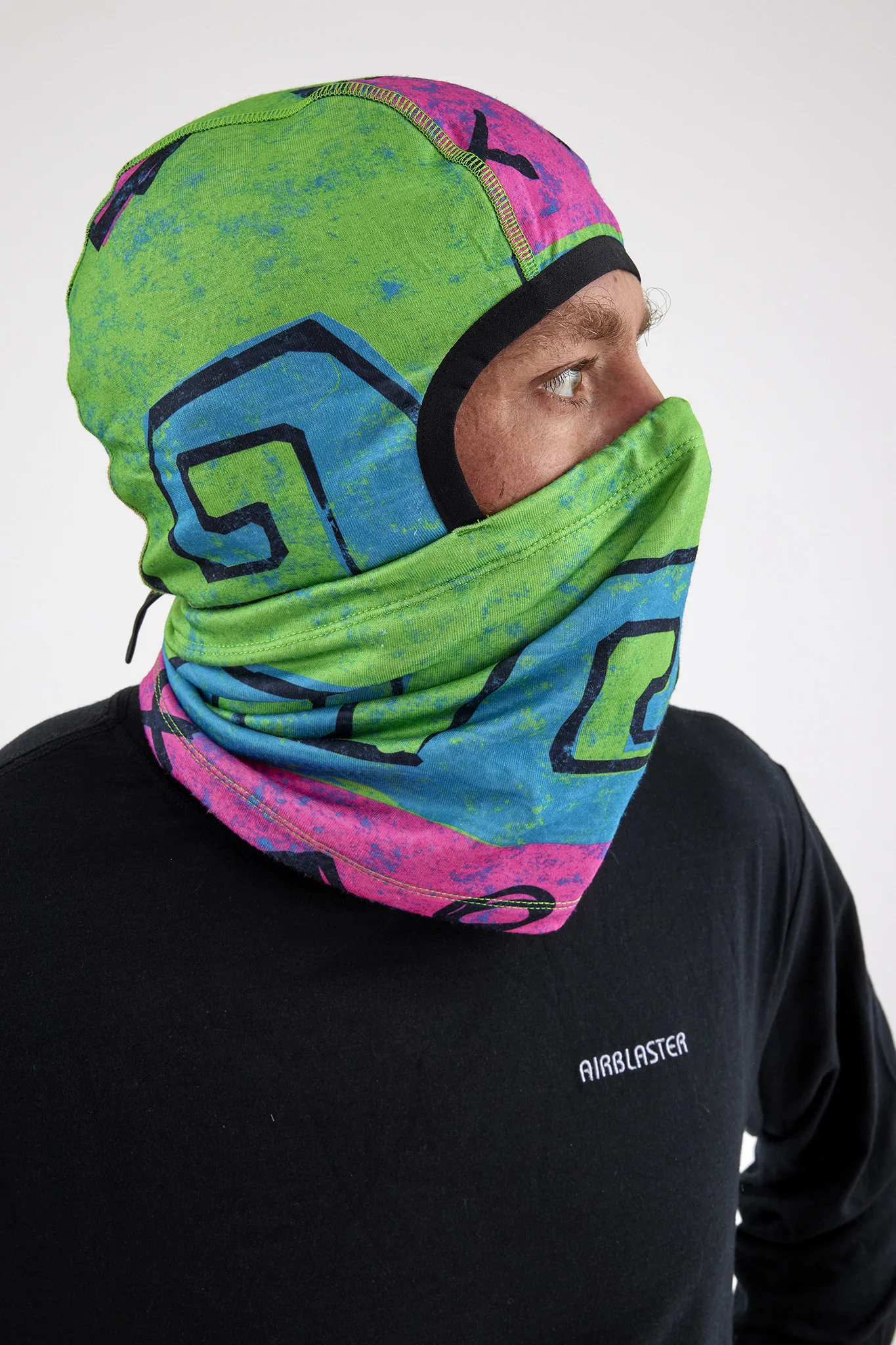 Person wearing a colorful neck gaiter with visible branding on a white background