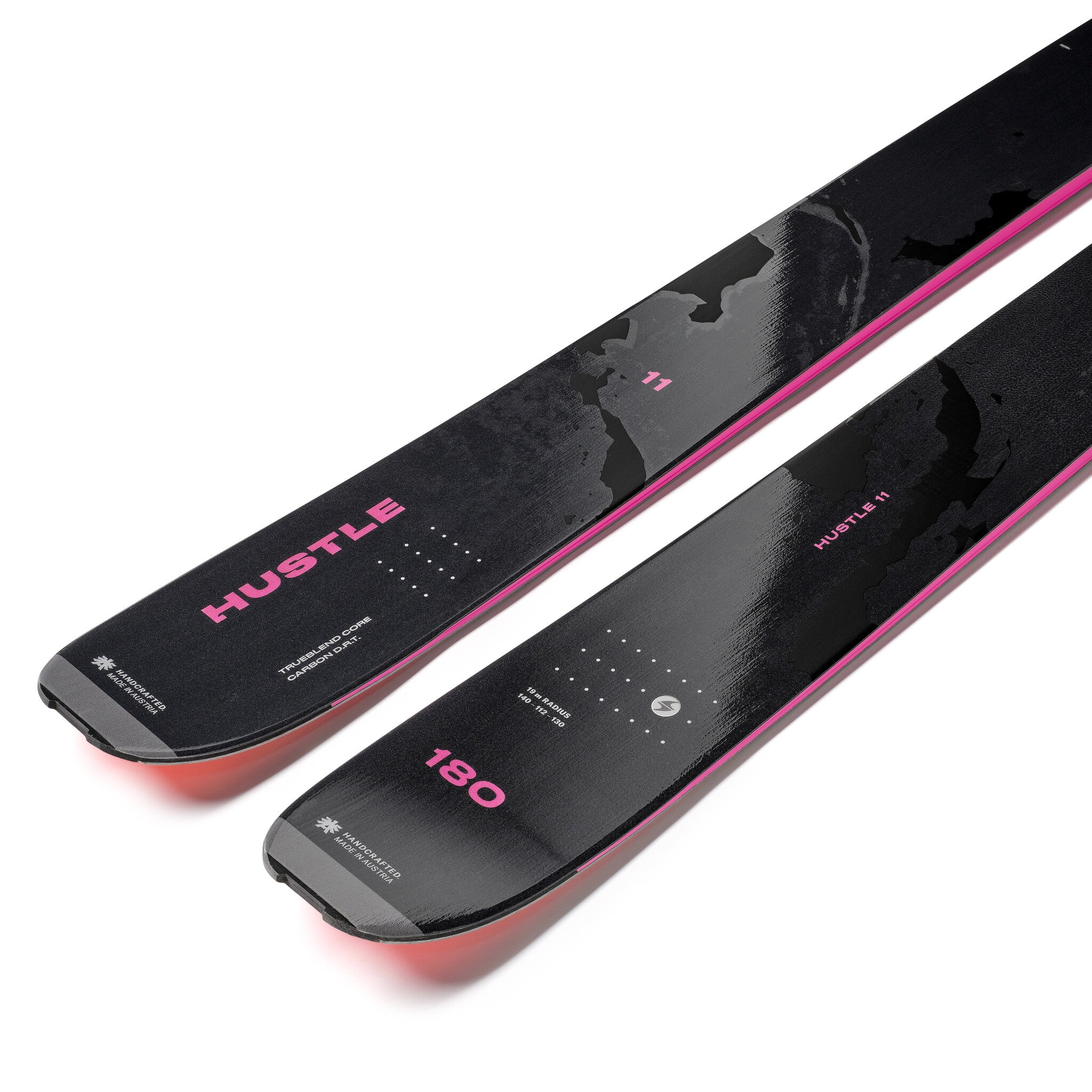 Two black and pink skis with 'Hustle' branding on a white background
