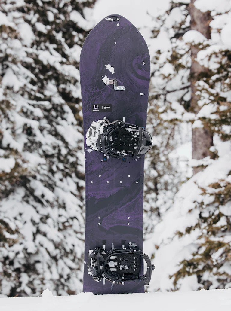 Purple snowboard with bindings on a snowy background