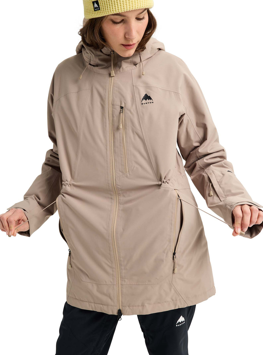 Person wearing a beige jacket with a brand logo on a white background