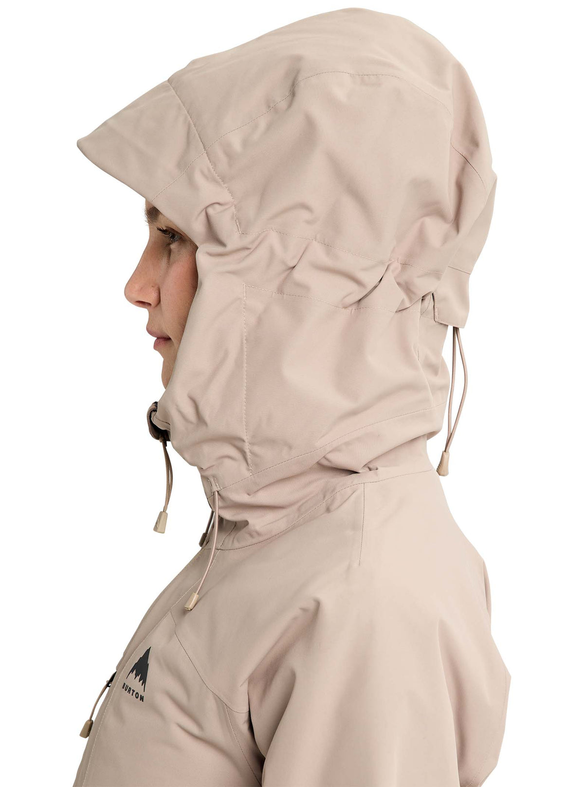 Person wearing a beige hooded jacket on a white background