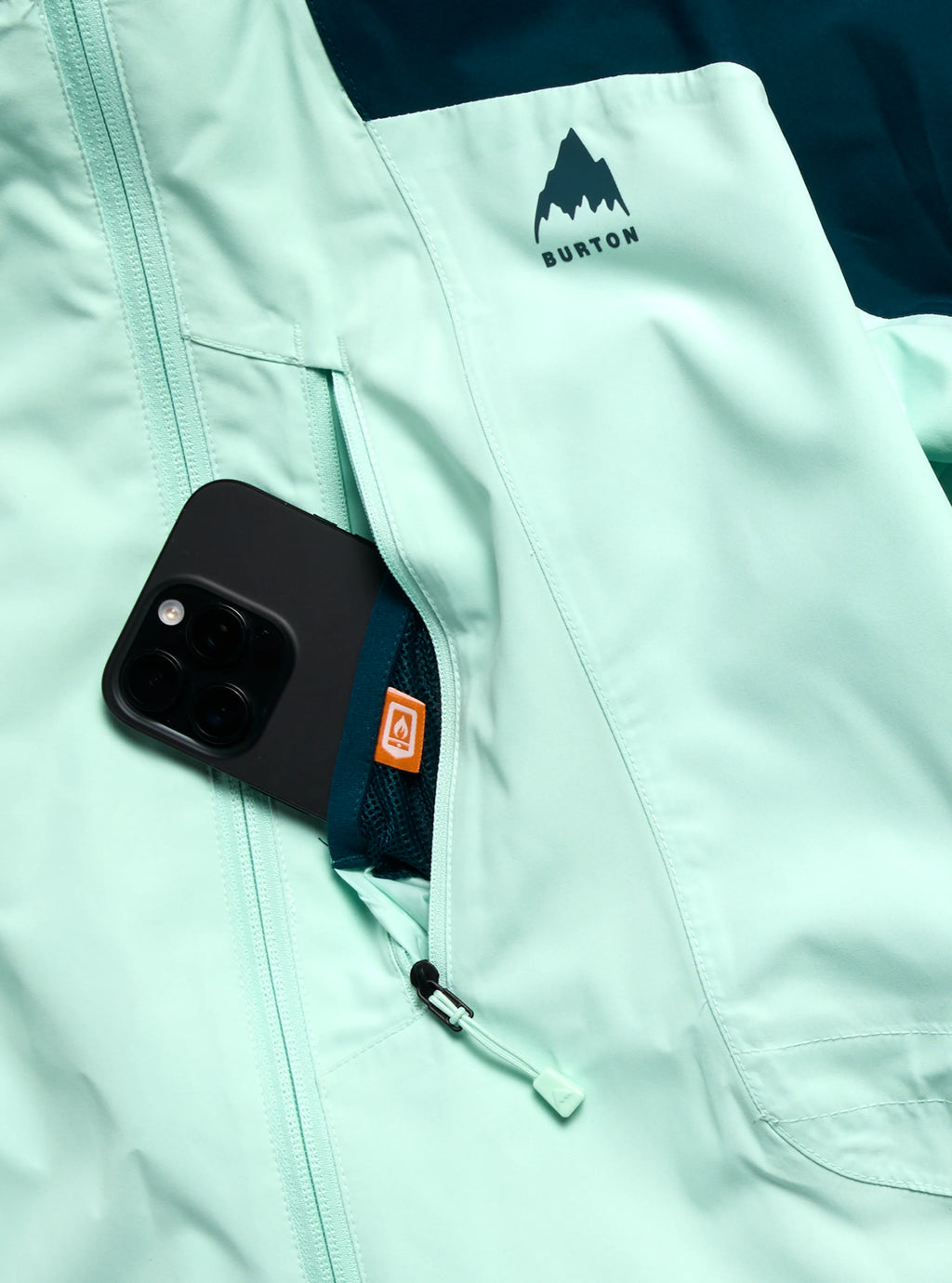 Light blue jacket with a phone case in the pocket, featuring the Burton logo.