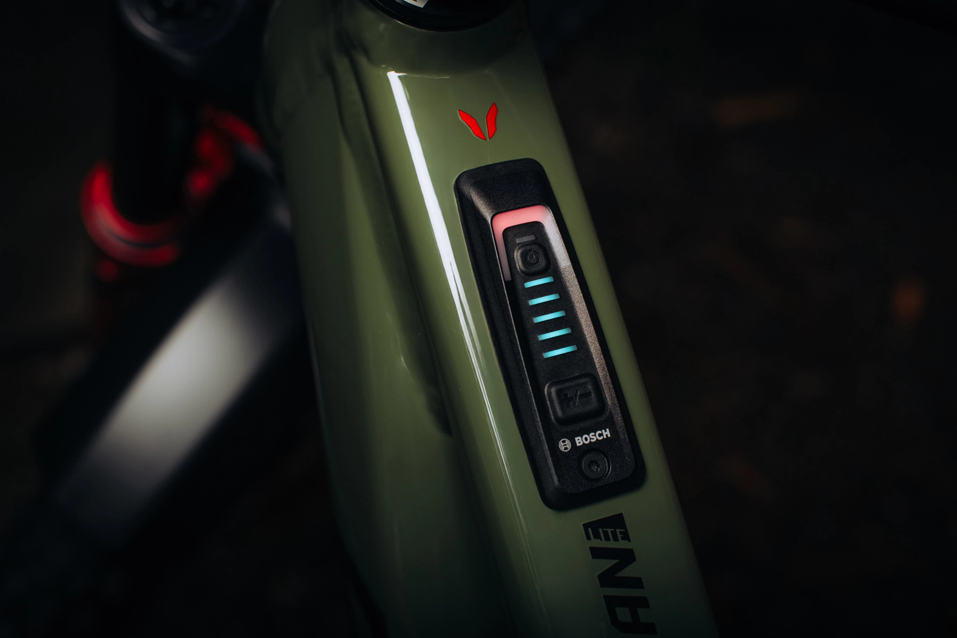 Close-up of a green electronic device with a brand logo on a dark background