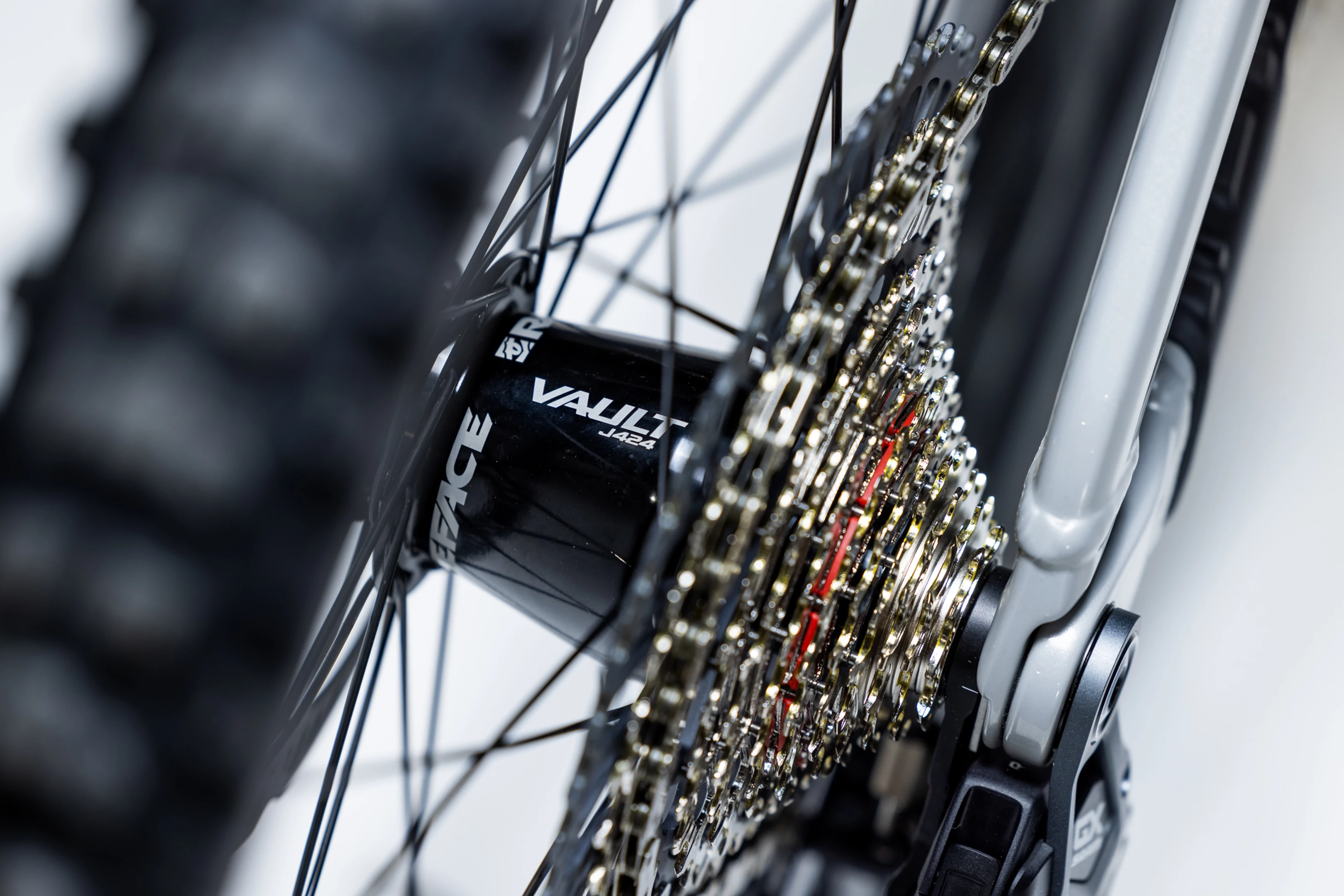 Close-up of a bicycle chain and gear system with a 'Vault' brand visible.