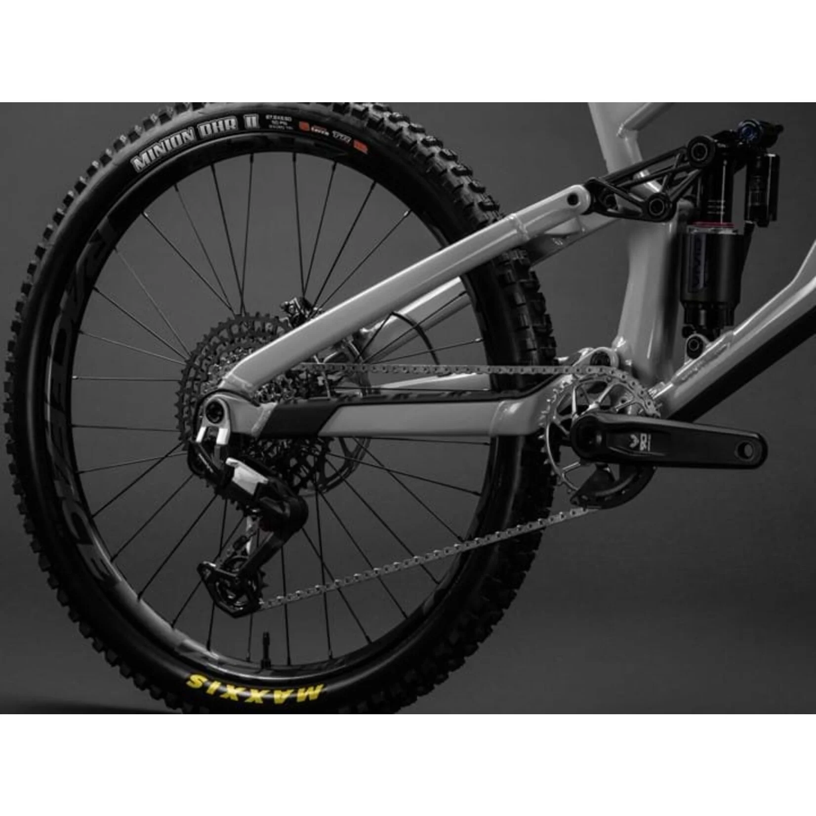 Close-up of a mountain bike's rear wheel and chain on a dark background