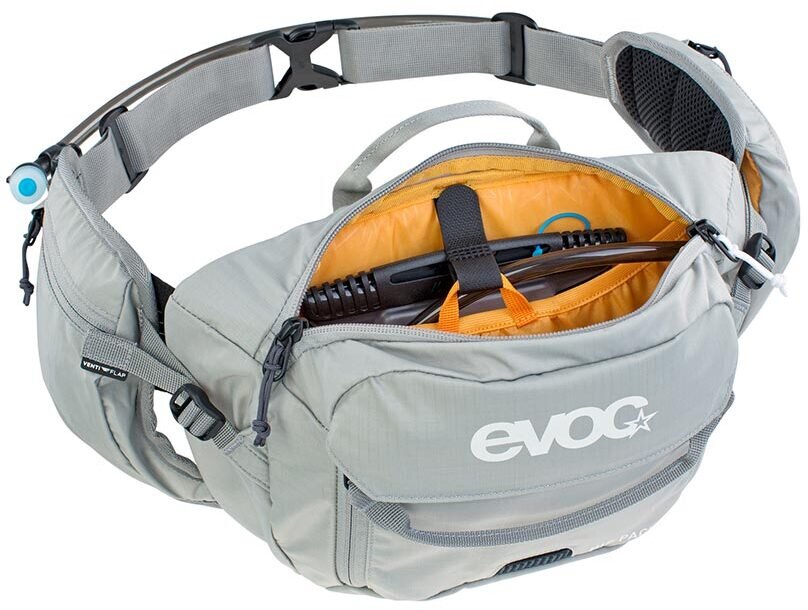 A light gray Evoc hiking waist bag with an open top zipper revealing an orange interior, shown on a white background.