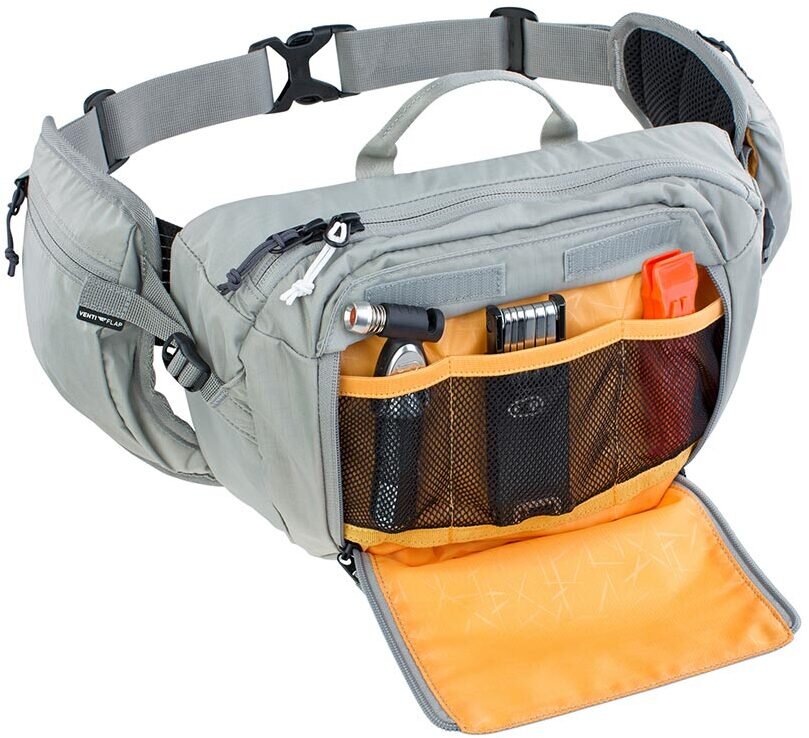 A light gray waist bag with an open front pocket showing an orange interior organizer, mesh pockets, and various small accessories, photographed on a white background.