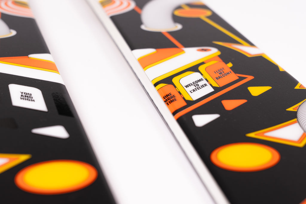 Close-up of a pair of skis with Halloween-themed design featuring pumpkins and text.