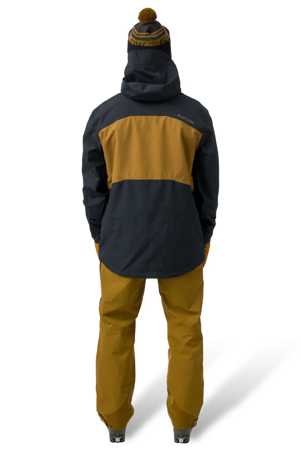 Person wearing a black and mustard-colored jacket with matching pants on a white background