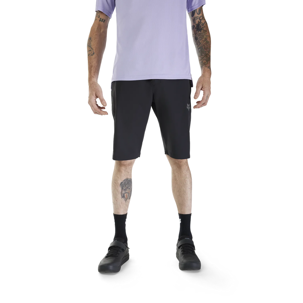 Person wearing black shorts and a light purple shirt on a white background