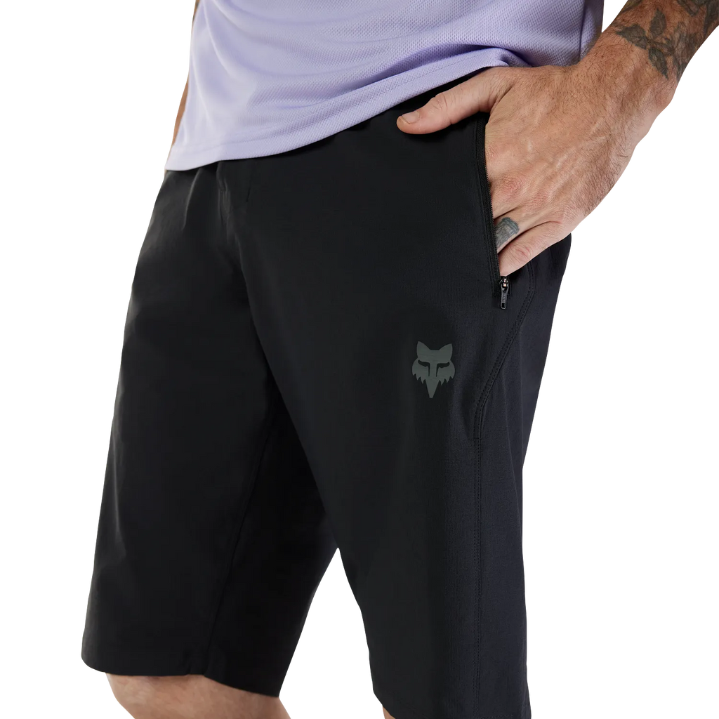 Person wearing black shorts with a logo on a white background