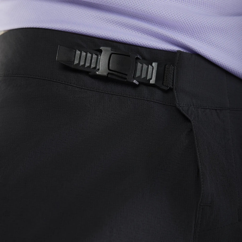 Close-up of black pants with a black belt and purple shirt.