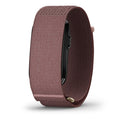 A close-up of a smartwatch band in a dusty rose or mauve-brown nylon fabric, shown on a white background with a soft shadow.