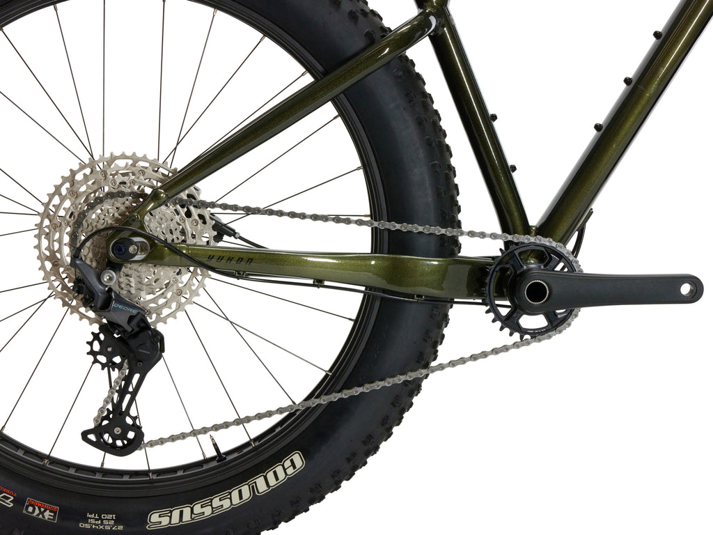 Close-up of a bicycle wheel with chain and gear on a white background