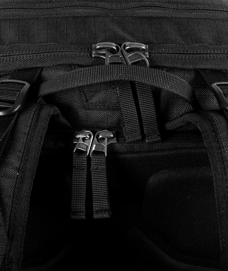 Close-up of a black tactical bag with straps and buckles.