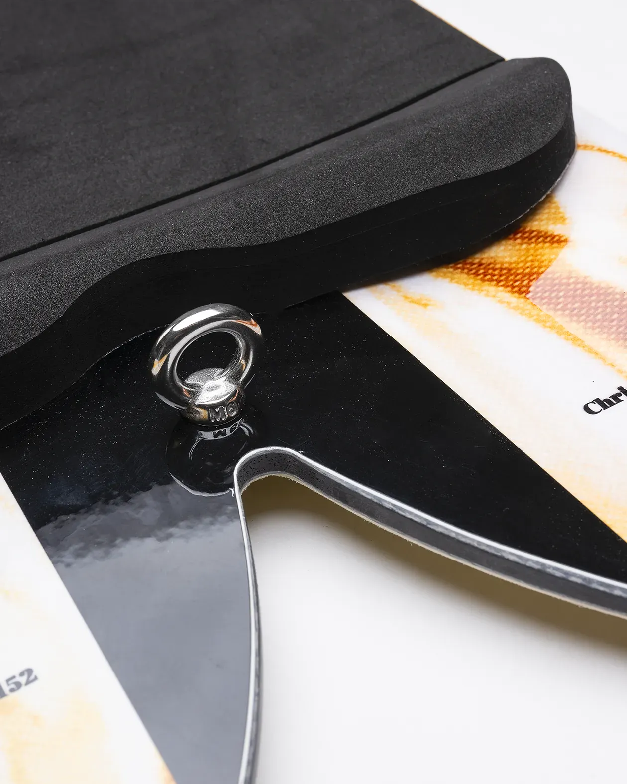 Close-up of a black pad with a silver clasp on a white background