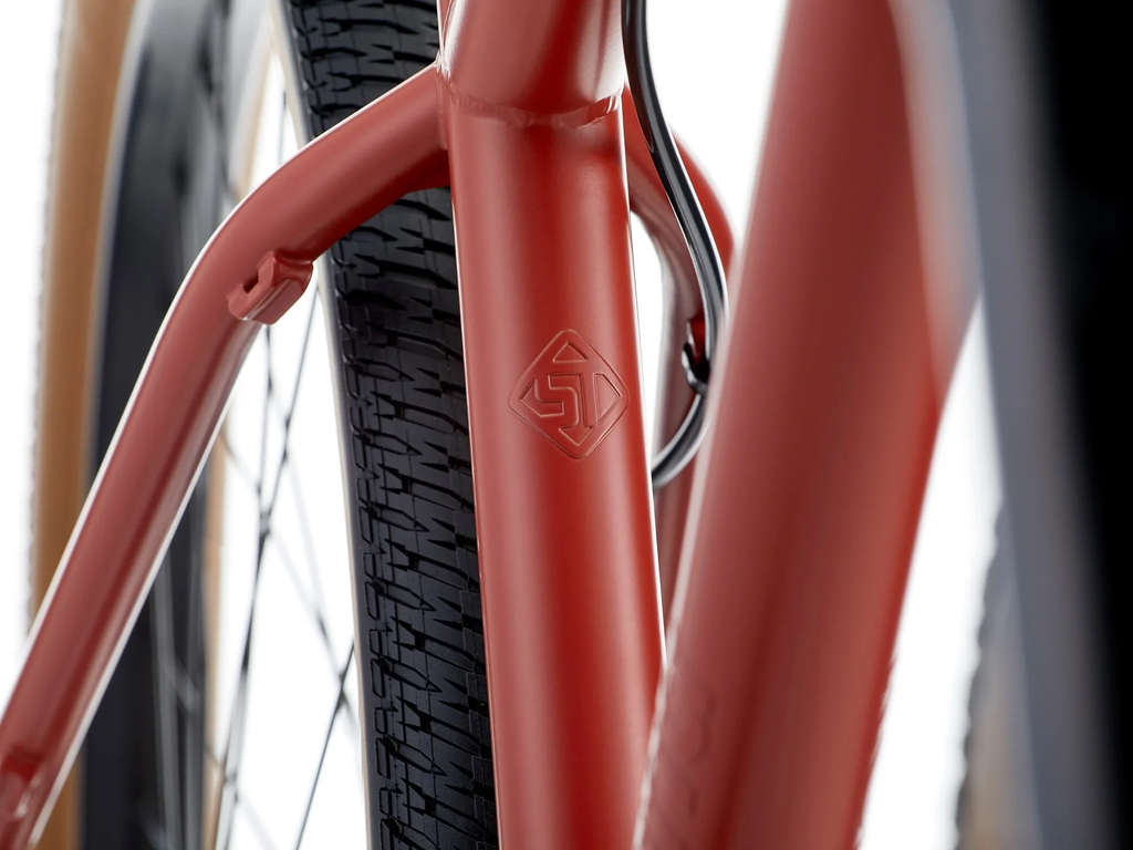 Close-up of a red bicycle frame with a blurred background