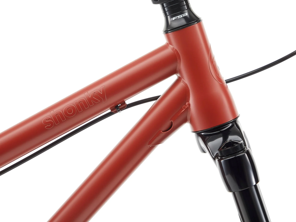 Close-up of a red bicycle frame with 'Shonky' branding on a white background