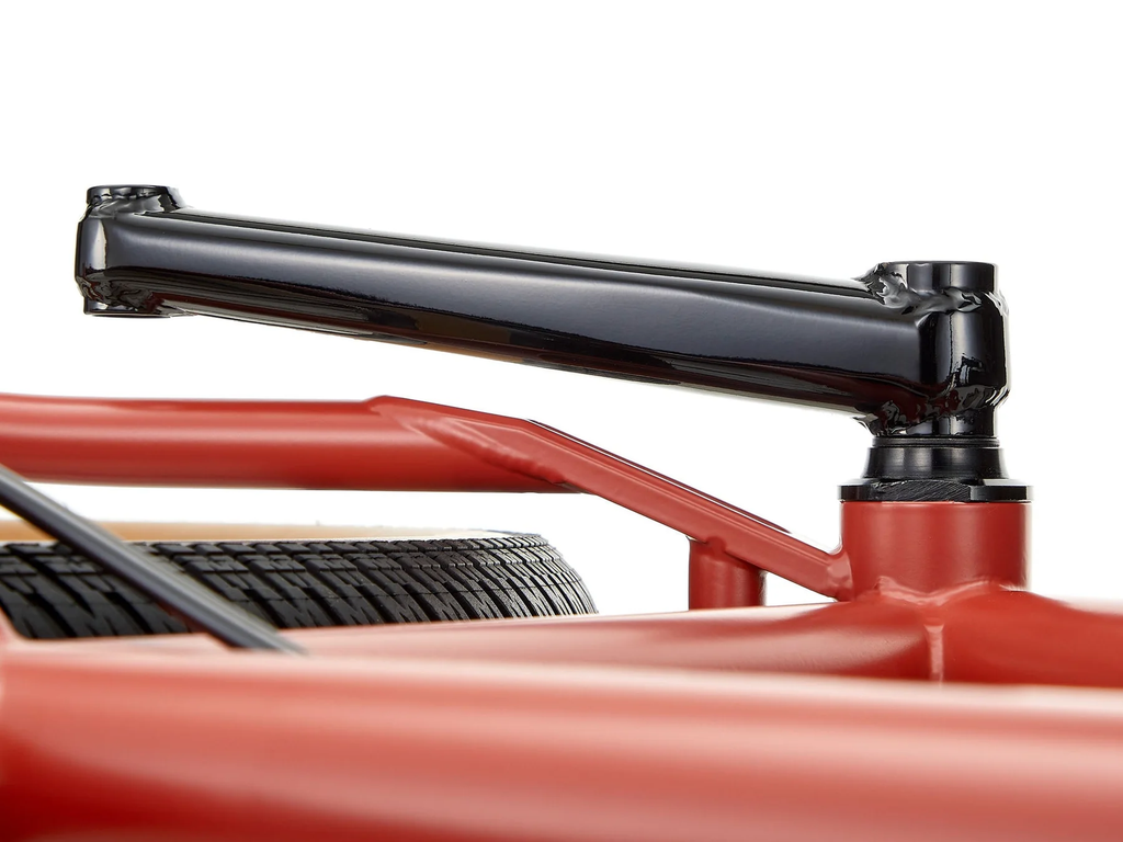 Close-up of a red bicycle frame with black components on a white background