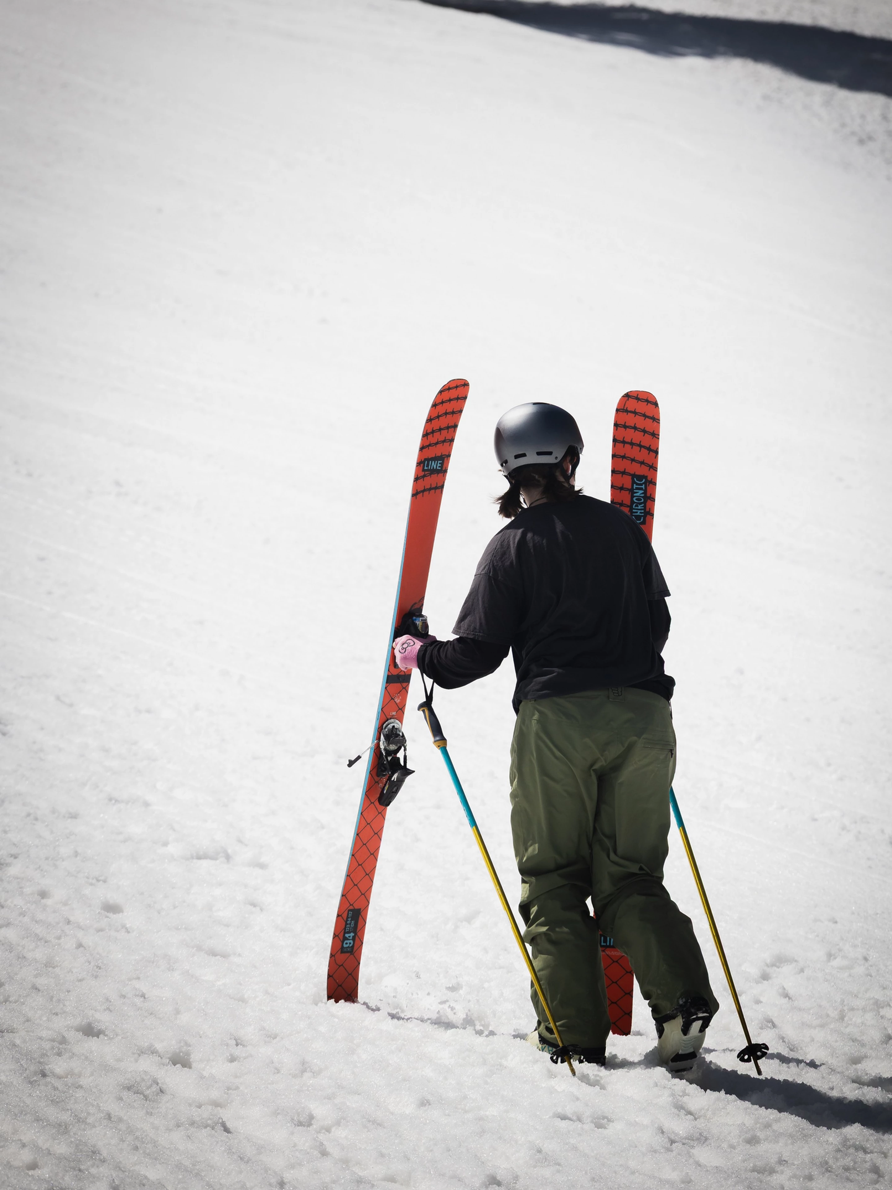 Person in ski gear with skis and poles on a snowy slope