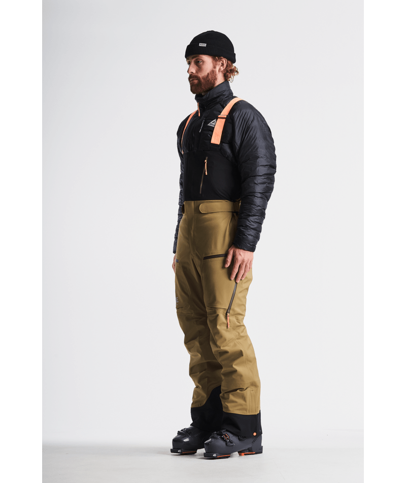 Man wearing a black jacket, tan pants, and black boots on a white background