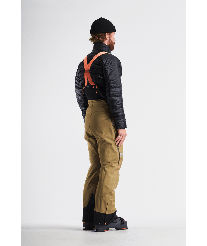 Person wearing a black jacket, tan pants, and orange suspenders on a white background