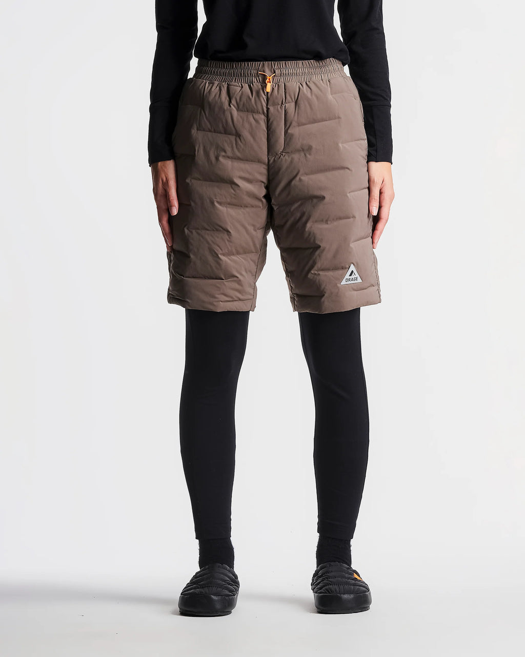 Person wearing brown puffer shorts on a white background