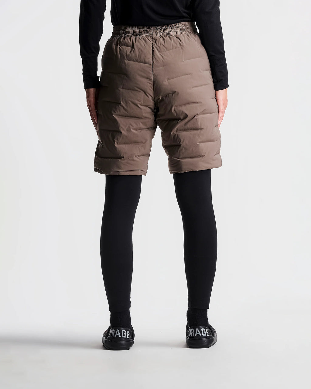 Person wearing brown puffer shorts on a white background