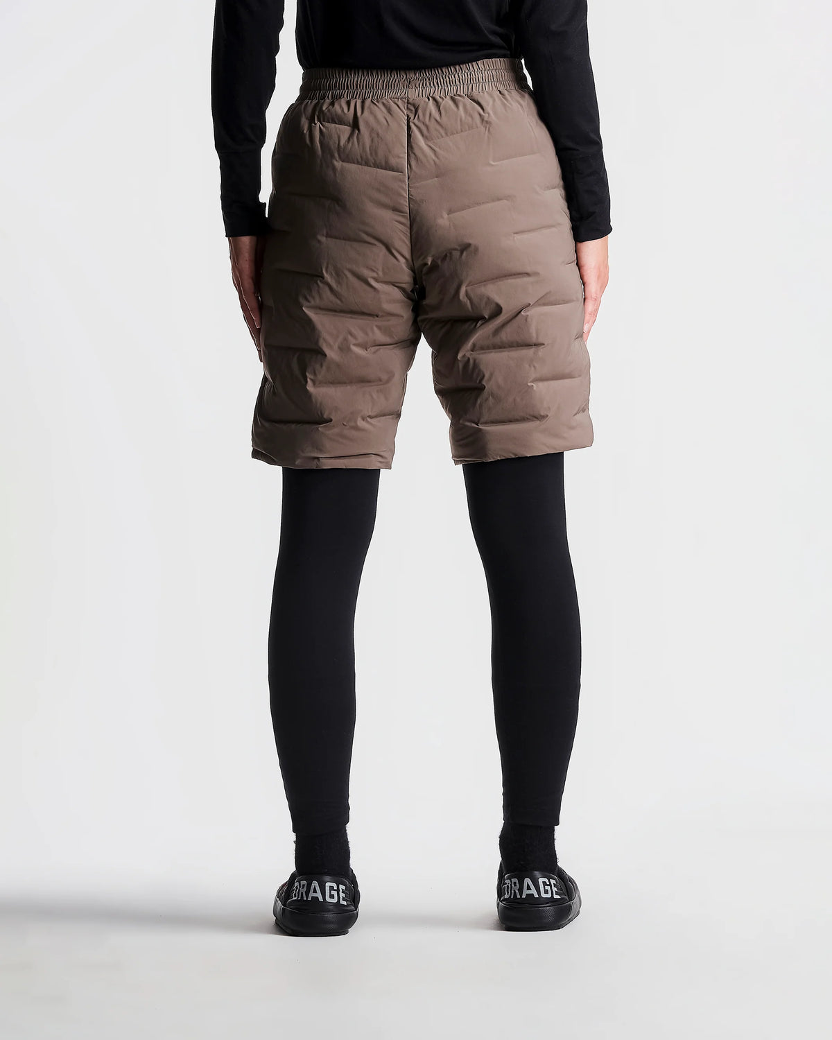 Person wearing brown puffer shorts on a white background