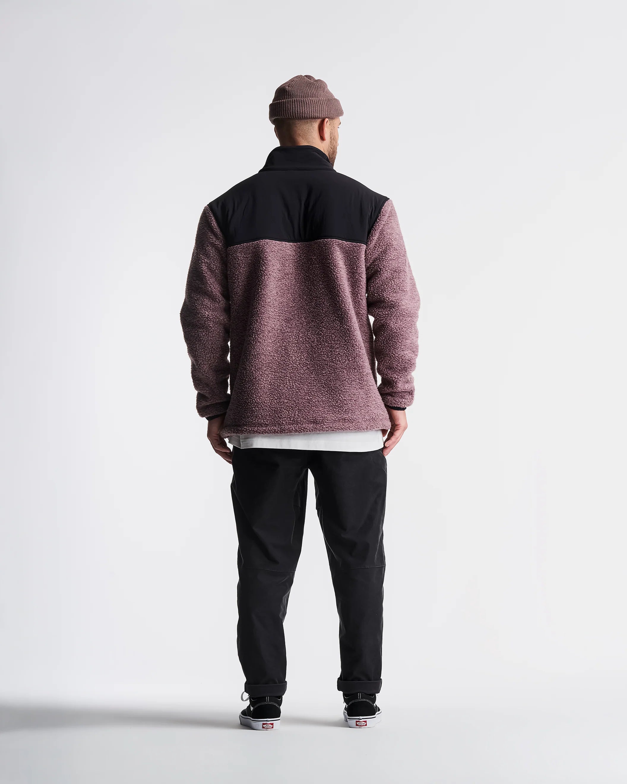 Person wearing a two-tone jacket with black and maroon colors on a white background