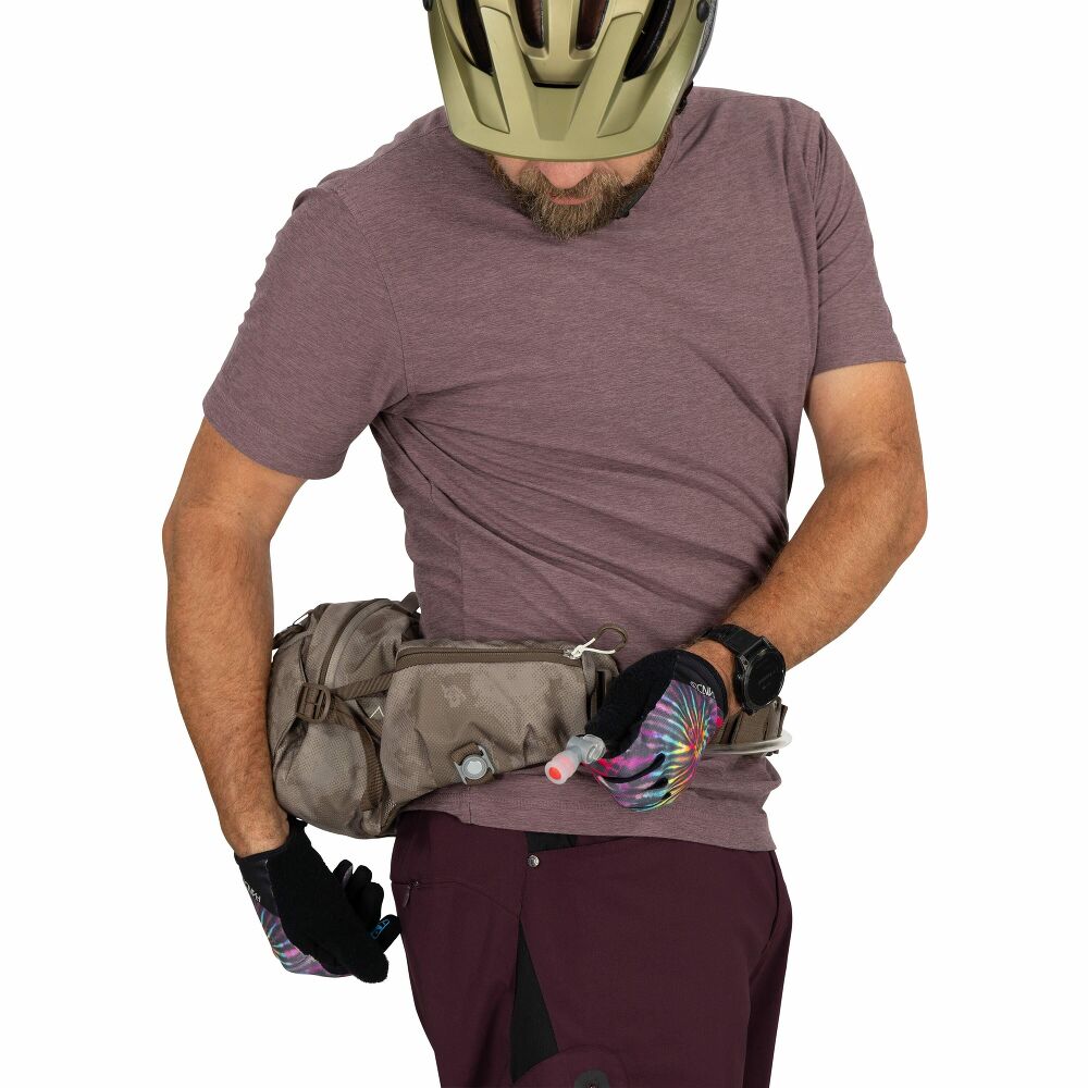 Man wearing a helmet and holding a waist bag with a white background