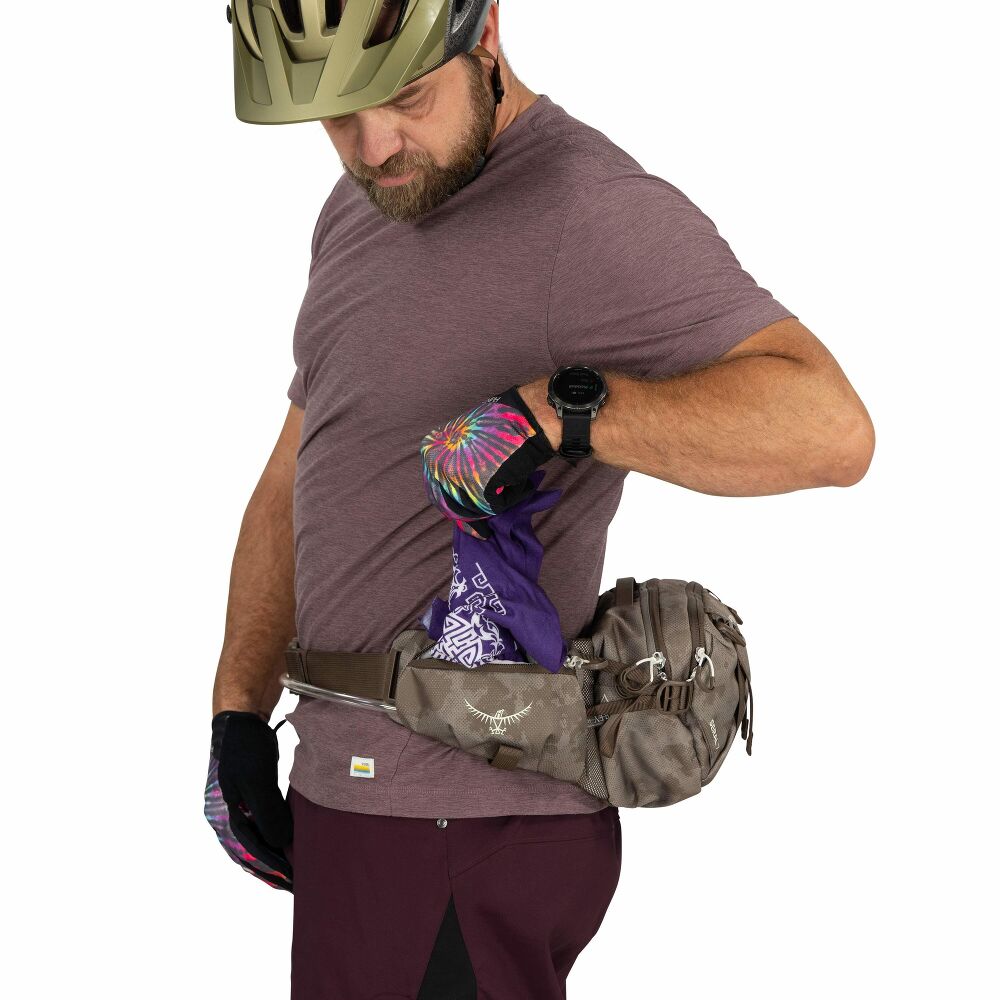 Man wearing a helmet and fanny pack, with a focus on outdoor or adventure activity.