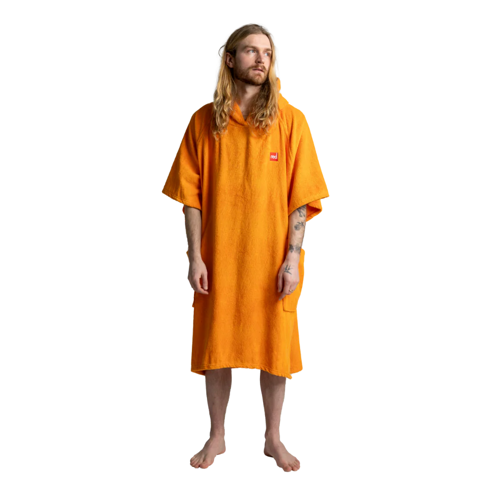 A man with long blonde hair and a beard wearing a bright orange hooded towel robe, standing against a plain white background.