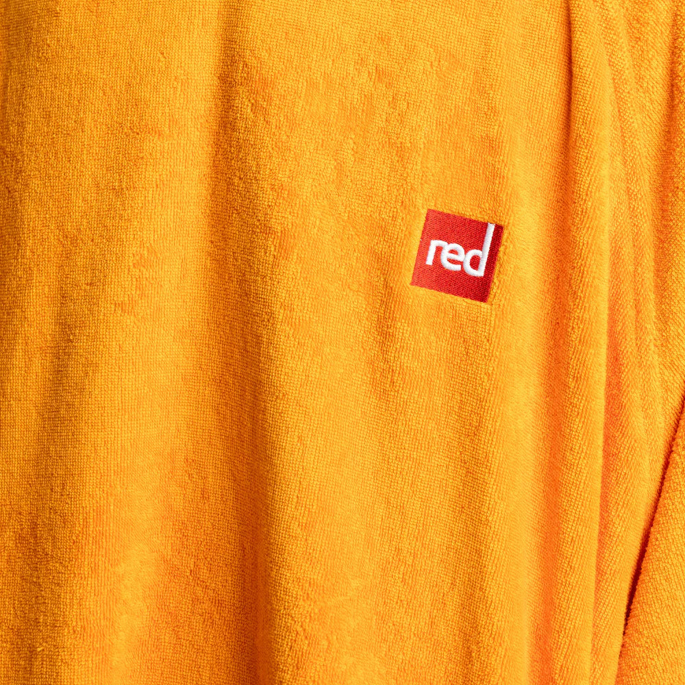 Close-up of an orange fabric with a red 'red' logo patch.