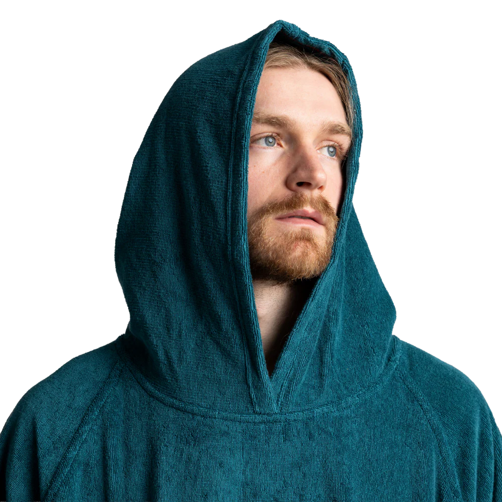 A man wearing a dark teal textured hooded robe or sweatshirt, shown from the chest up against a plain white background.