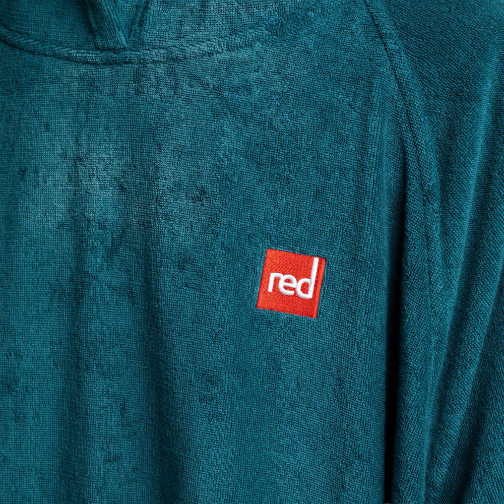 Teal sweatshirt with a red 'red' logo patch on a textured fabric background
