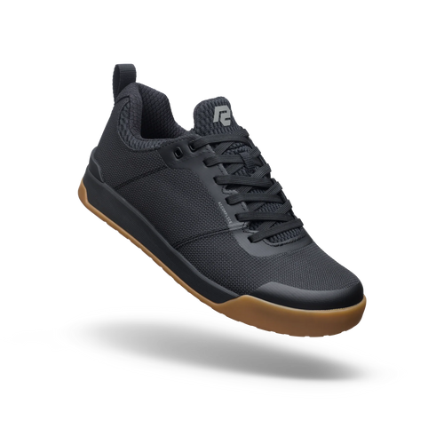 Black sneaker with brown sole on a white background