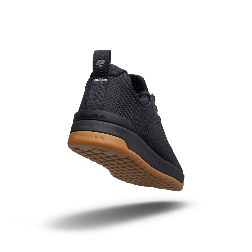 Black athletic shoe with brown sole on a white background
