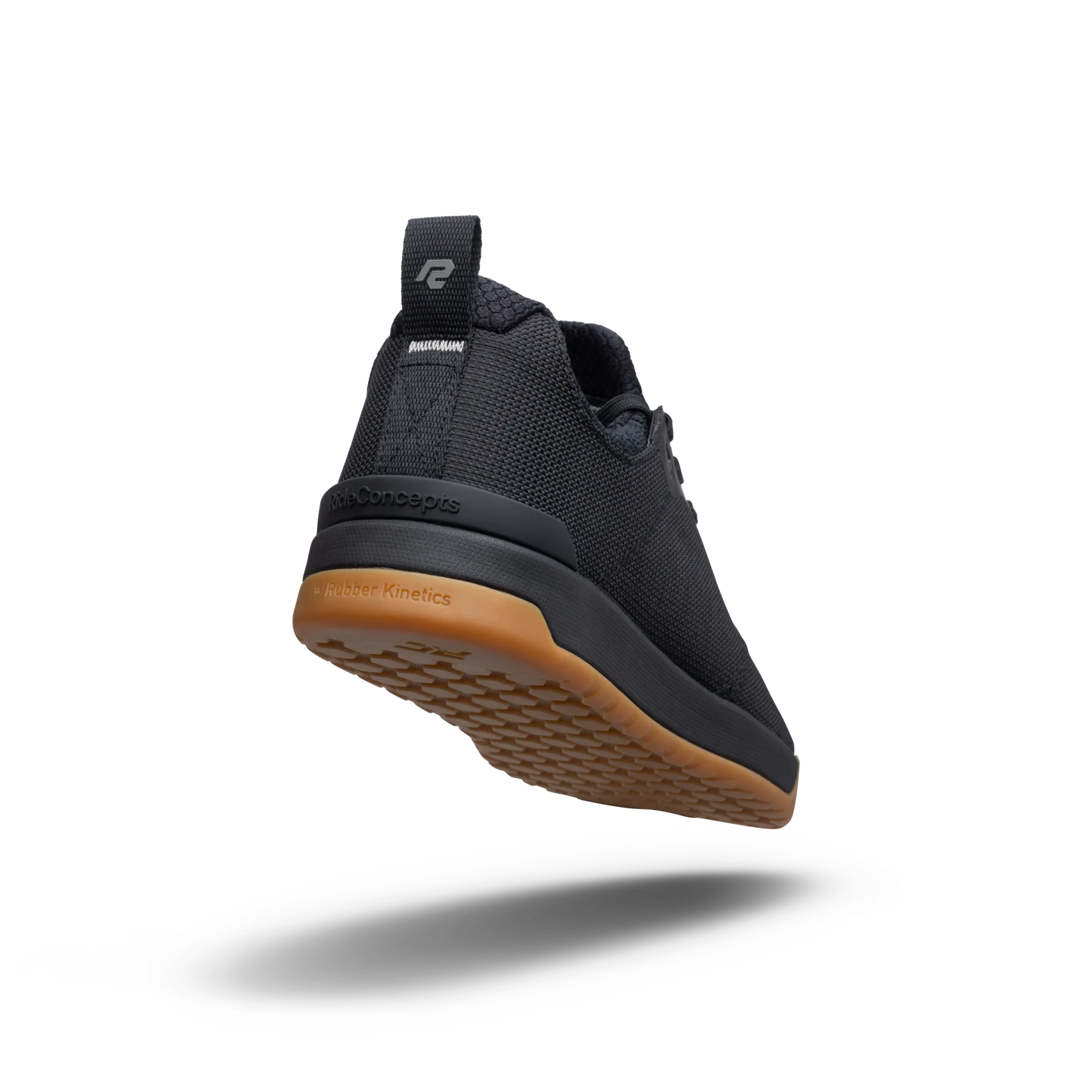 Black athletic shoe with brown sole on a white background