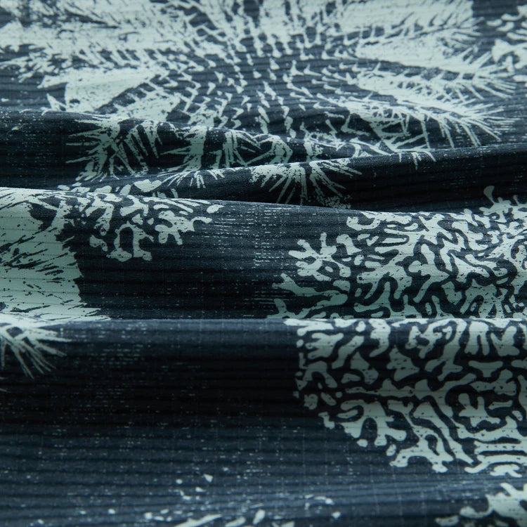 Textured fabric with black and white pattern on a dark background
