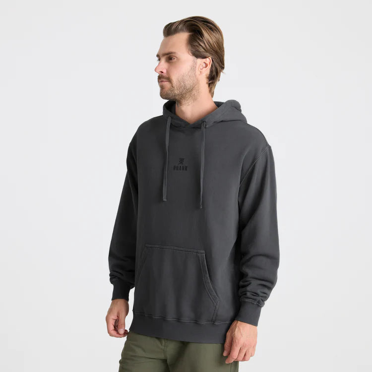 Man wearing a dark gray hoodie with a small logo on a light gray background