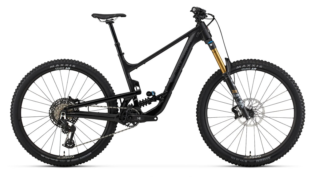A black full-suspension mountain bike with a gold Fox front fork, knobby Maxxis tires, and a rear shock, shown from a side profile on a white background.