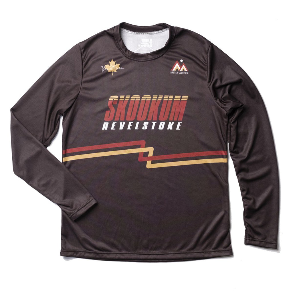 Brown long-sleeve shirt with 'Skookum Revelstoke' text and logos on a white background