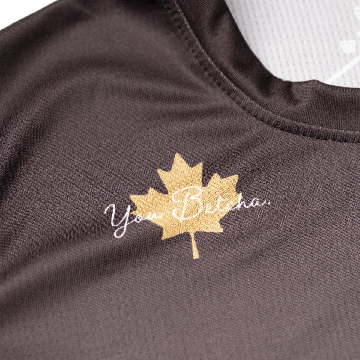 Brown garment with a gold maple leaf design and text on a white background