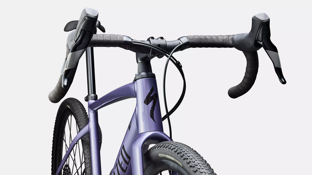 Close-up of a purple bicycle with black handlebars on a white background