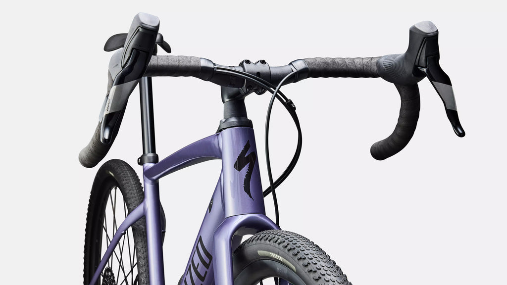 Close-up of a purple bicycle with black handlebars on a white background