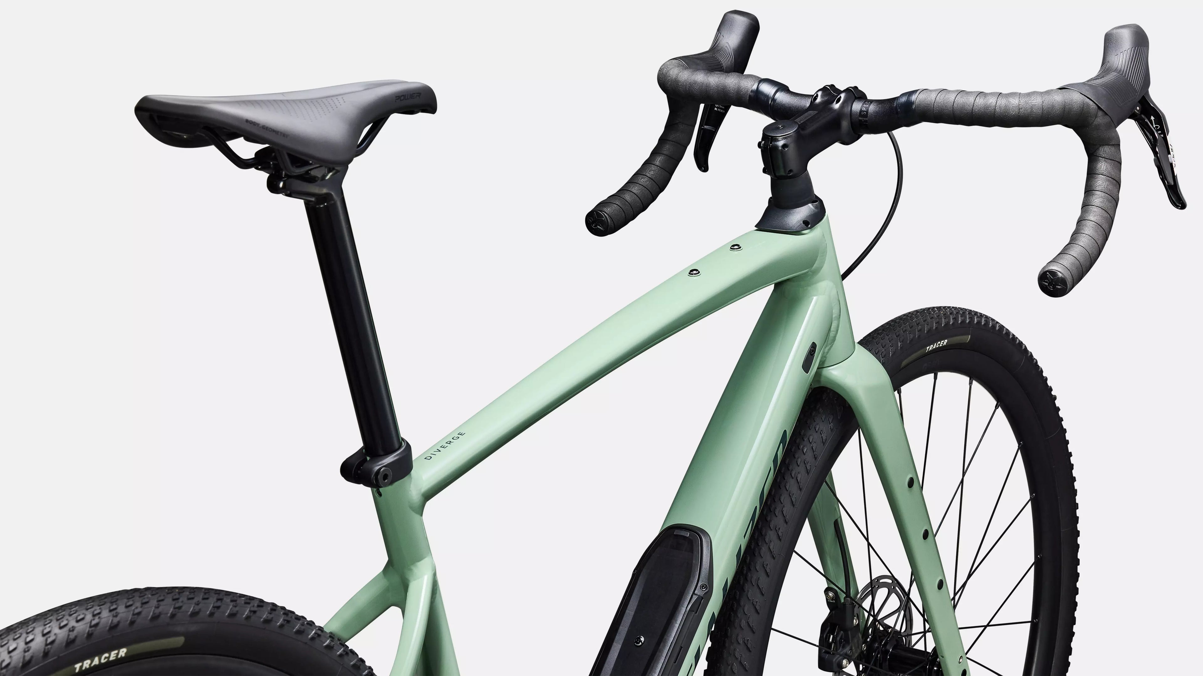 Green bicycle with black components on a light gray background