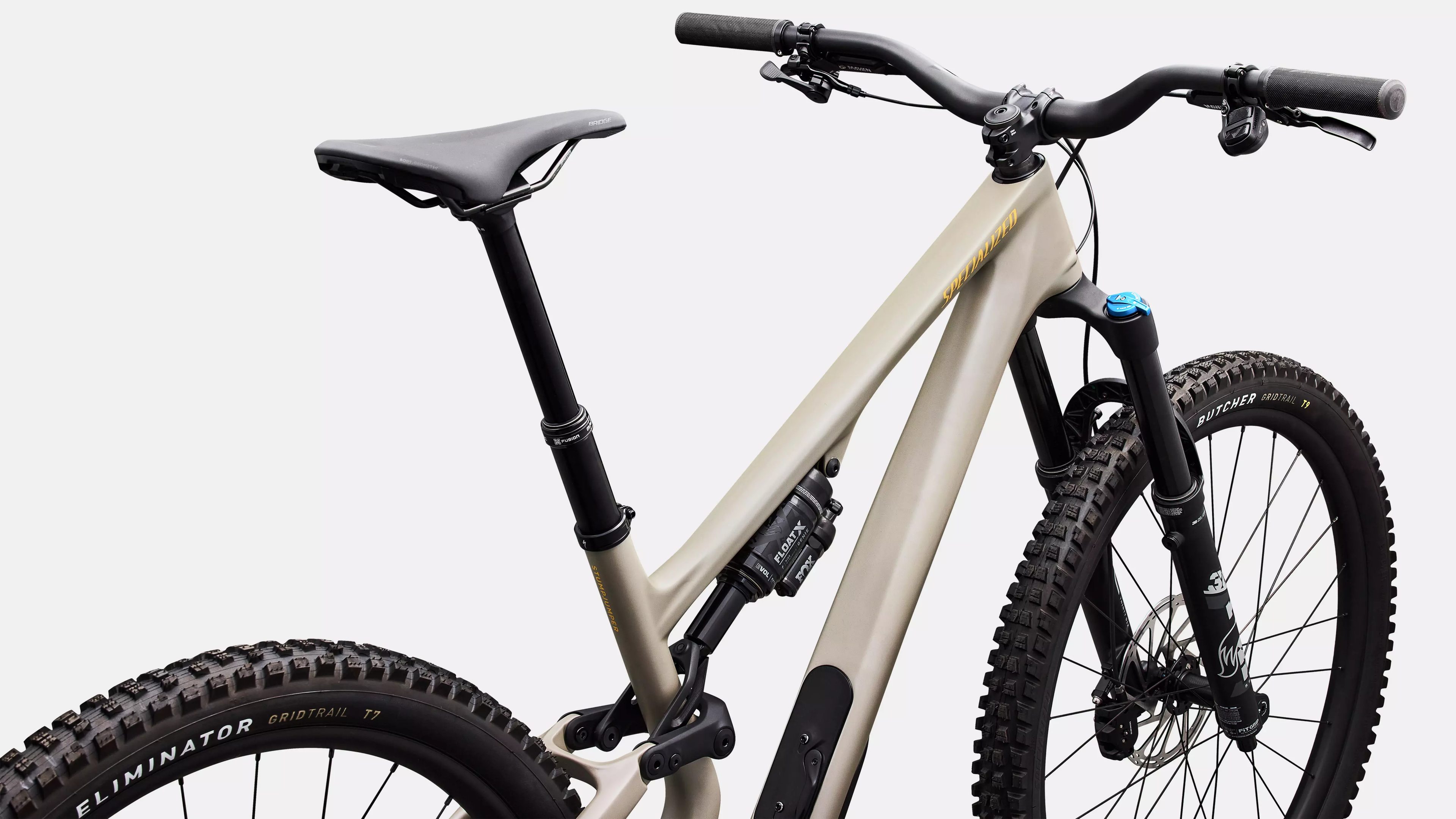 Beige mountain bike with black components on a white background