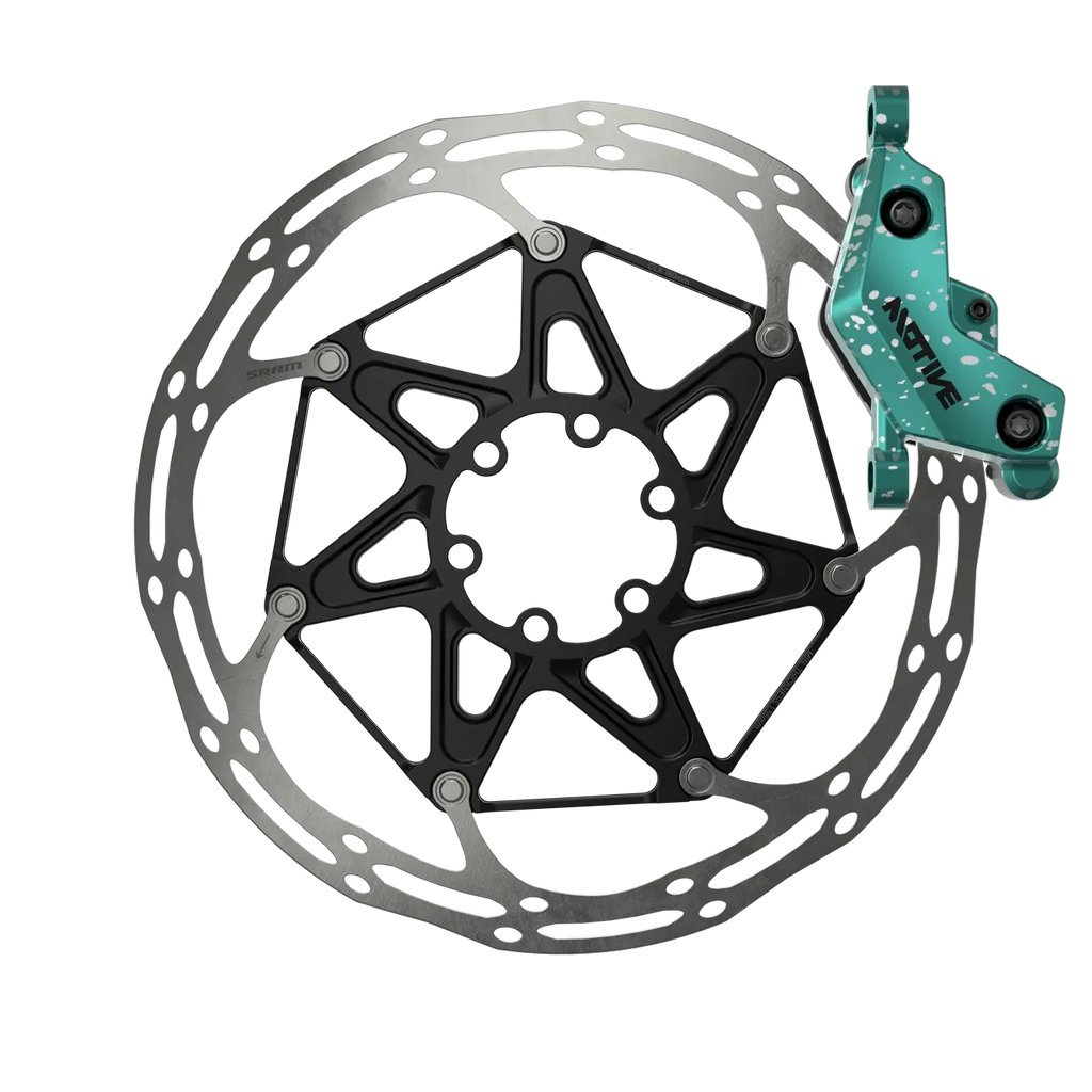 Bicycle disc brake rotor with green caliper on a white background