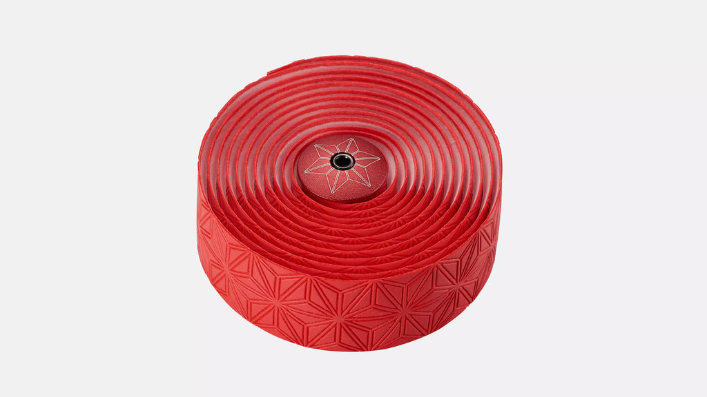 A roll of red bicycle tape with a textured geometric pattern and a central star logo, shown on a light gray background.